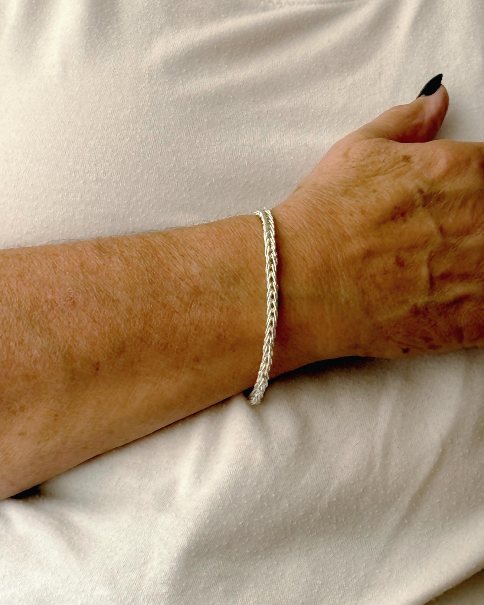 Evelyn Fine Silver Bracelet by Carabella, designed by Cheryl, worn on the wrist—handcrafted in Canada from .999 fine silver with a sterling clasp, a timeless expression of quiet luxury and artisan elegance.