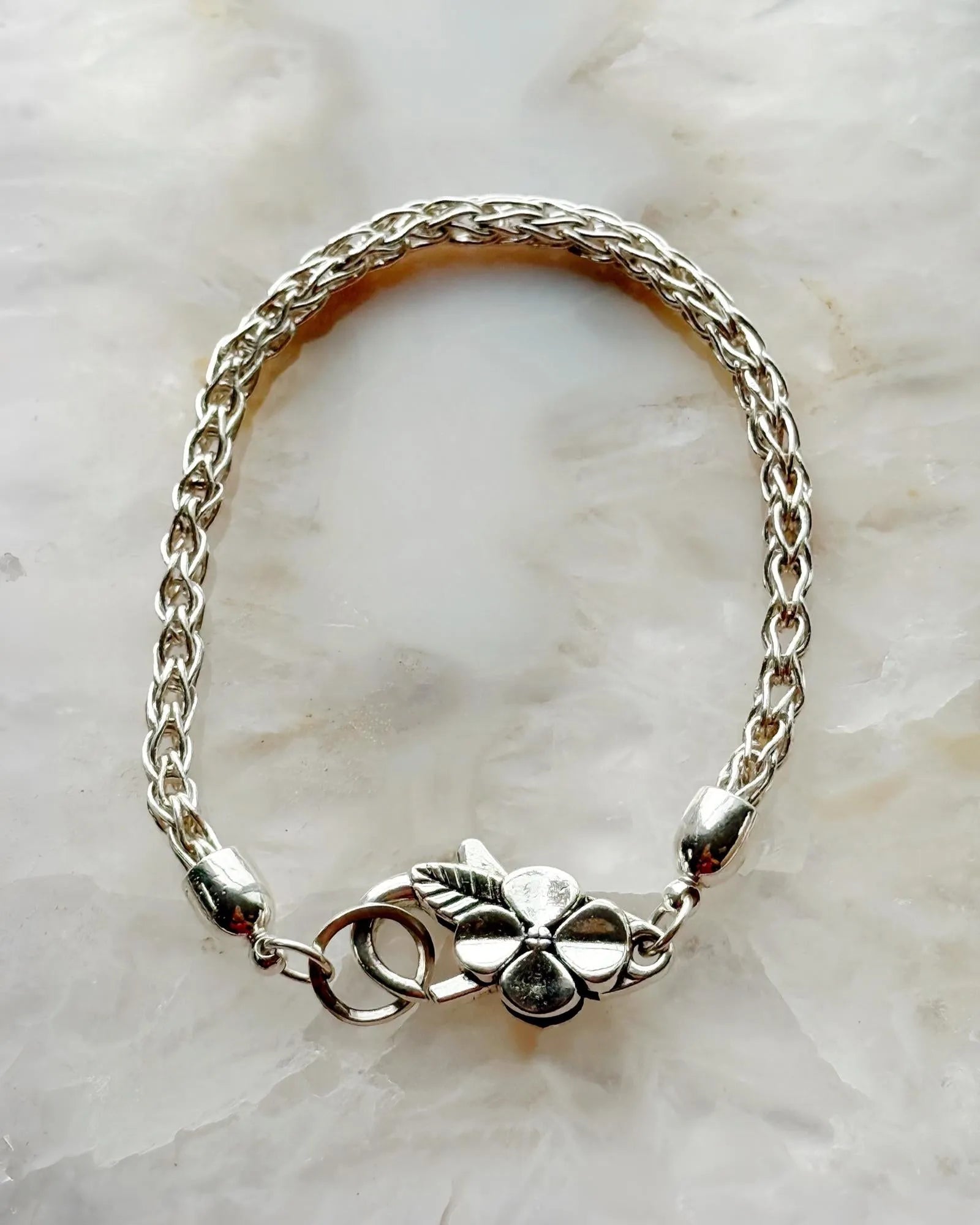 Close-up of the Gemma Fine Silver Bracelet’s handwoven .999 silver chain and botanical clasp, handcrafted by Carabella by Cheryl.