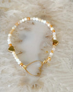 Model wearing the Harlow Gold Stretch Bracelet with honey opal gemstones and gold heart detail, an elegant everyday bracelet for women