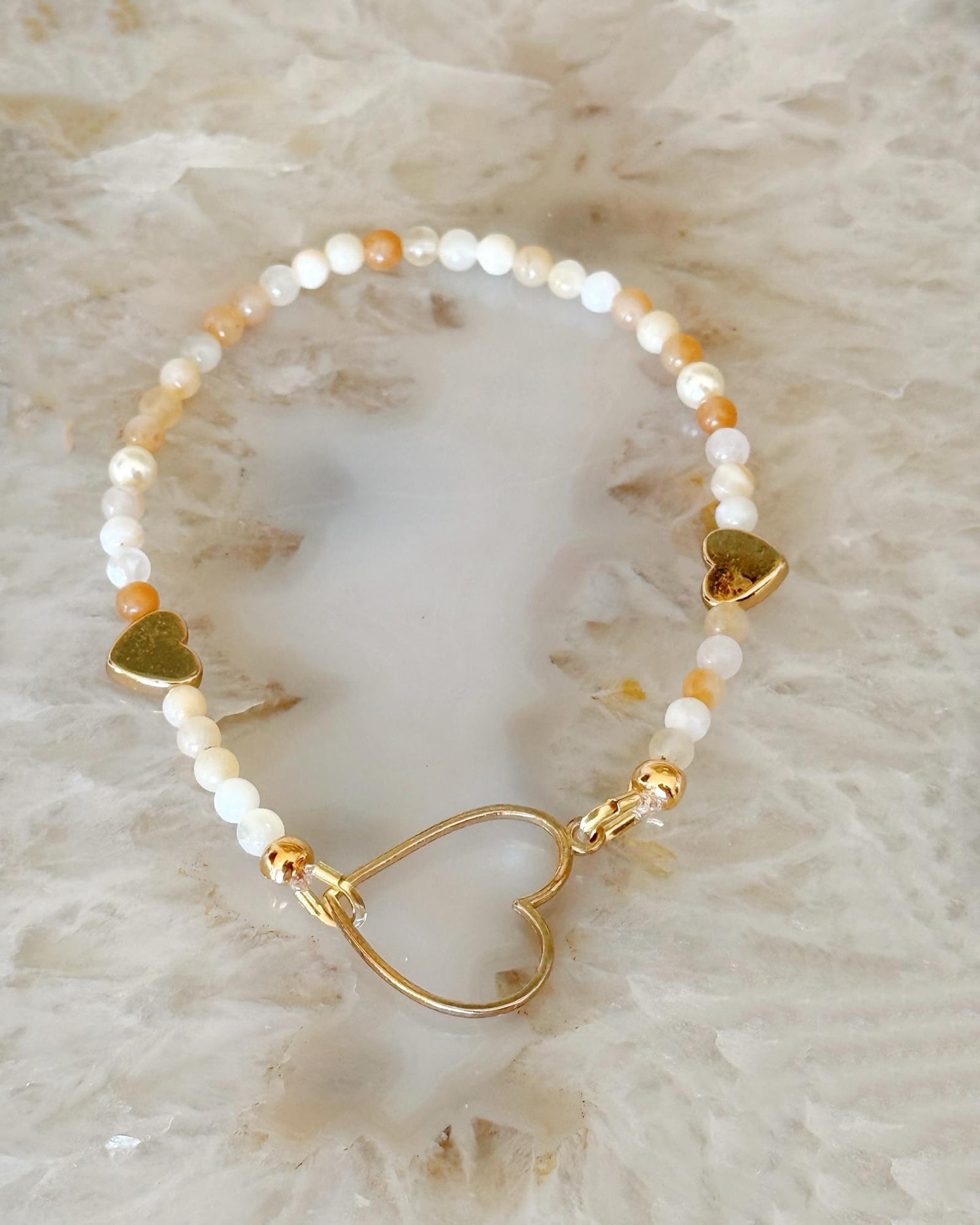 Model wearing the Harlow Gold Stretch Bracelet with honey opal gemstones and gold heart detail, an elegant everyday bracelet for women