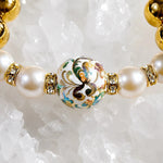 Close-up detail of the Imperial Blossom Bracelet featuring a rare Japanese Tensha focal bead, Swarovski® Crystal Pearls, crystal rondelles, and polished gold hematite gemstones on a quartz crystal surface.