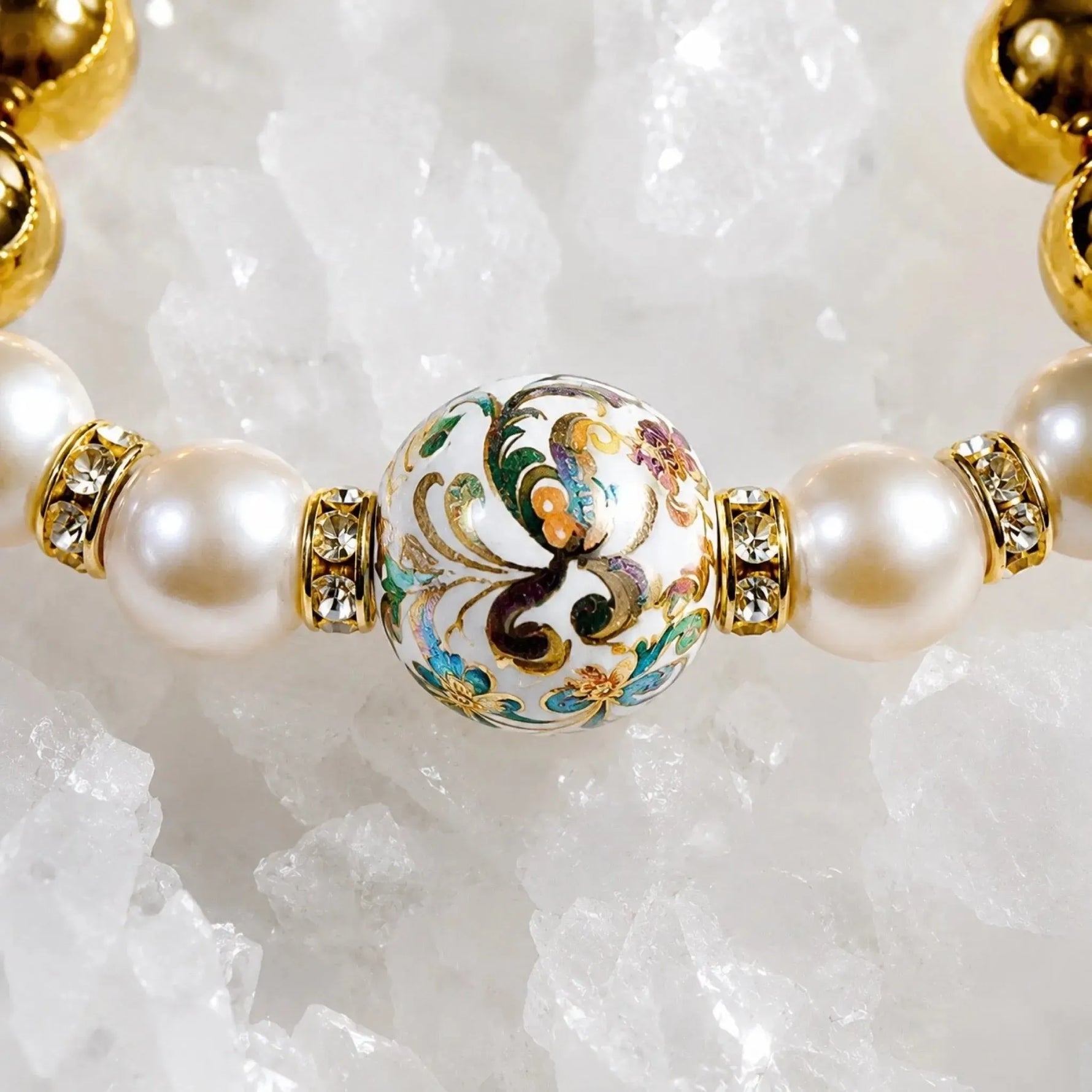 Close-up detail of the Imperial Blossom Bracelet featuring a rare Japanese Tensha focal bead, Swarovski® Crystal Pearls, crystal rondelles, and polished gold hematite gemstones on a quartz crystal surface.