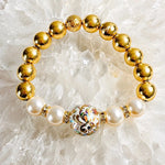 Luxury Imperial Blossom Bracelet with rare Japanese Tensha bead, Swarovski® Crystal Pearls, crystal accents, and gold hematite gemstones photographed on natural quartz crystal.