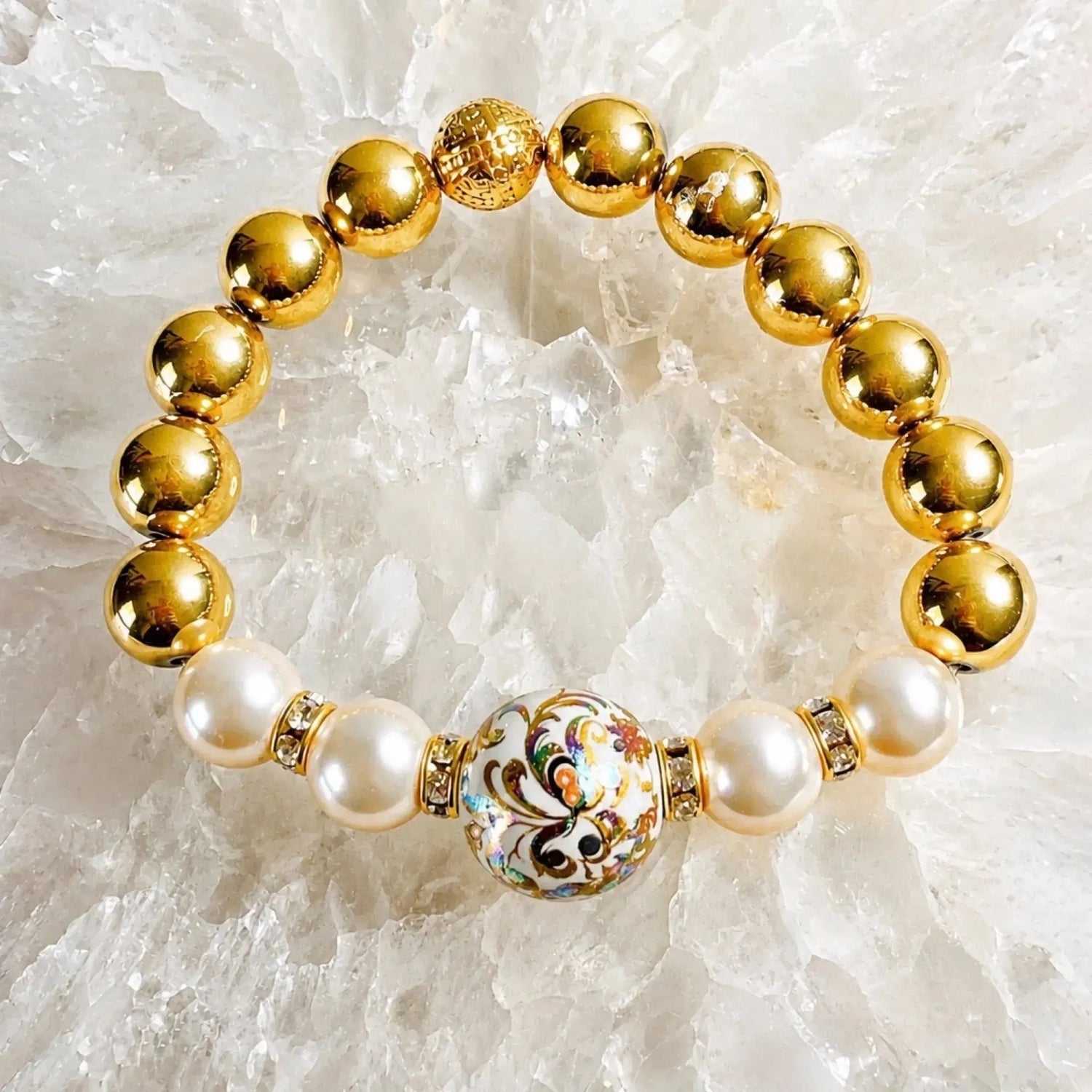 Luxury Imperial Blossom Bracelet with rare Japanese Tensha bead, Swarovski® Crystal Pearls, crystal accents, and gold hematite gemstones photographed on natural quartz crystal.