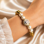 Model wearing the Imperial Blossom Bracelet featuring a rare Japanese Tensha bead, Swarovski® Crystal Pearls, crystal rondelles, and polished gold hematite gemstones in an elegant luxury lifestyle photograph.
