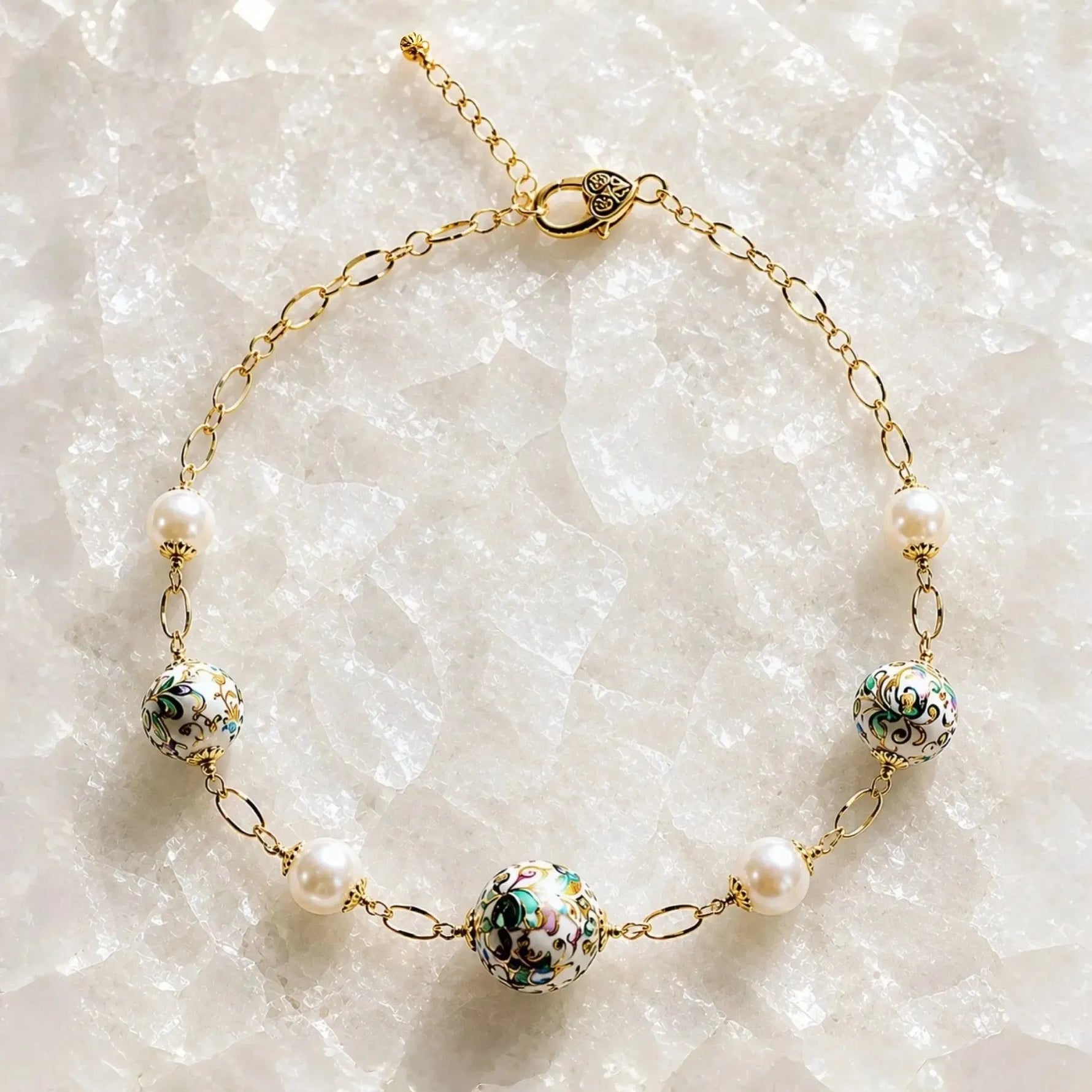 Imperial Blossom Necklace featuring rare Japanese Tensha beads, Swarovski® Crystal Pearls, and gold chain links arranged on a luminous quartz crystal surface in a luxury flat lay photograph.