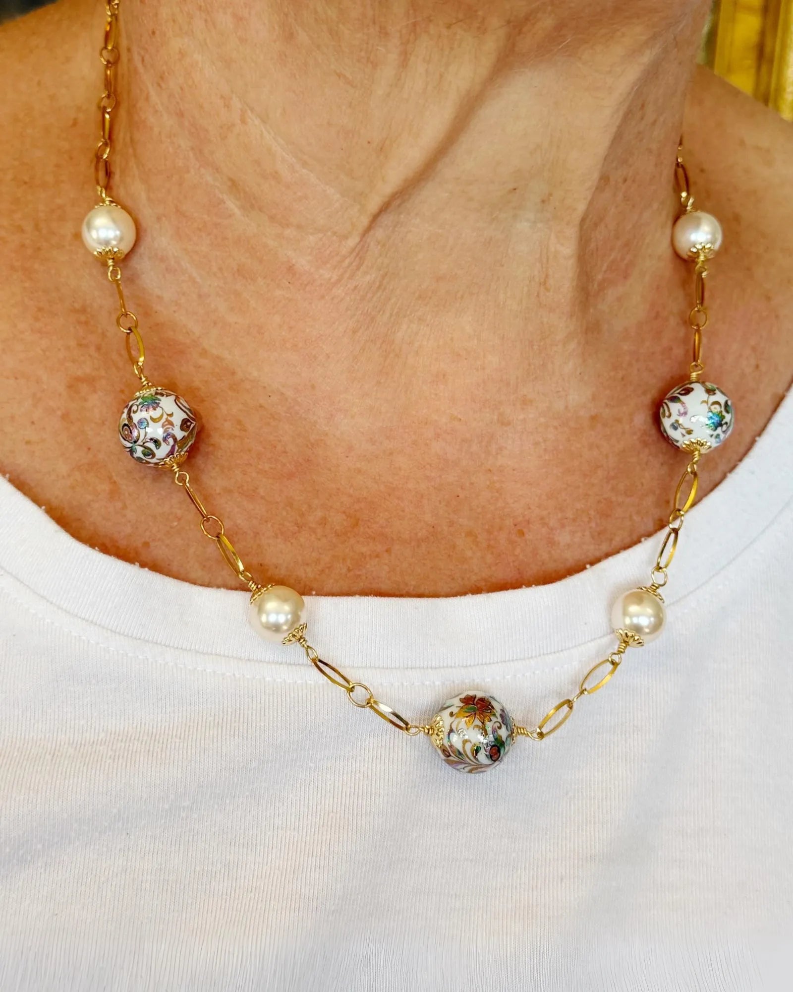 Model wearing the Imperial Blossom Necklace featuring Japanese Tensha beads, Austrian Crystal pearls, and gold-plated chain links. Handcrafted in Canada by Carabella by Cheryl.