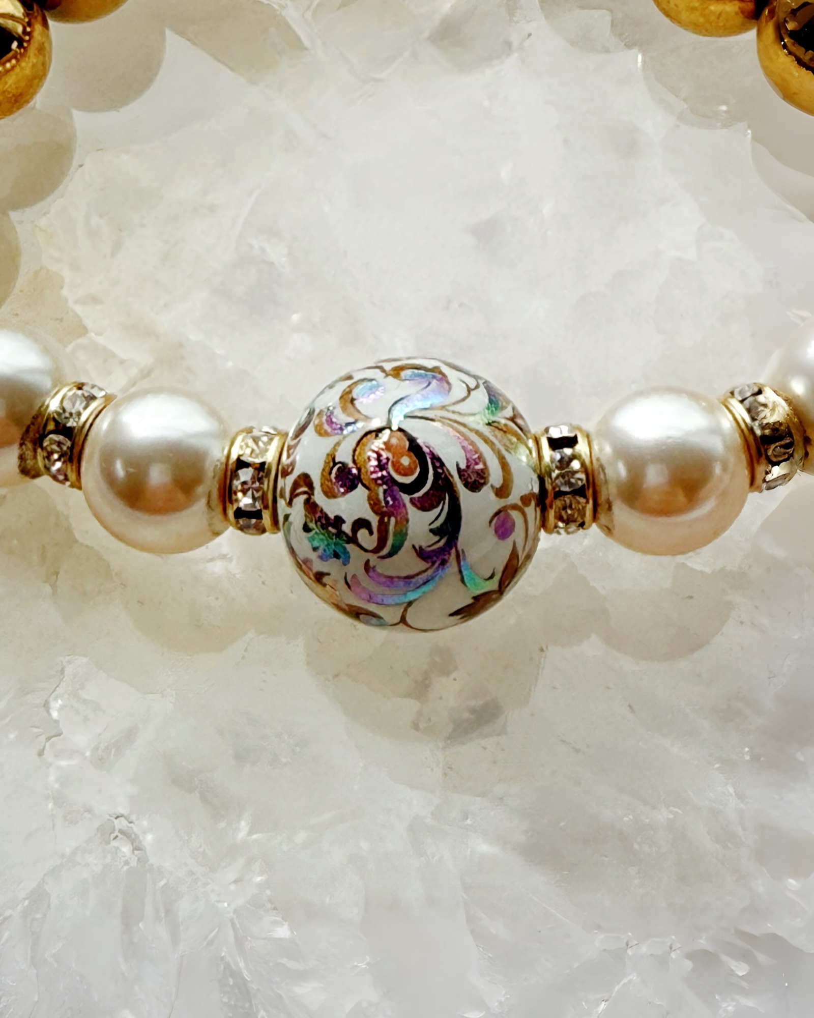Close-up of Imperial Blossom Bracelet showing the intricate Japanese Tensha bead with floral artwork, framed by Austrian Crystal pearls and gold-plated hematite.