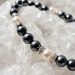 Close-up macro detail of the Jan Swarovski® Crystal Pearl Bracelet showcasing black and cream Swarovski® Crystal Pearls, sparkling crystal rondelles, and luxury handcrafted craftsmanship on white quartz crystals.