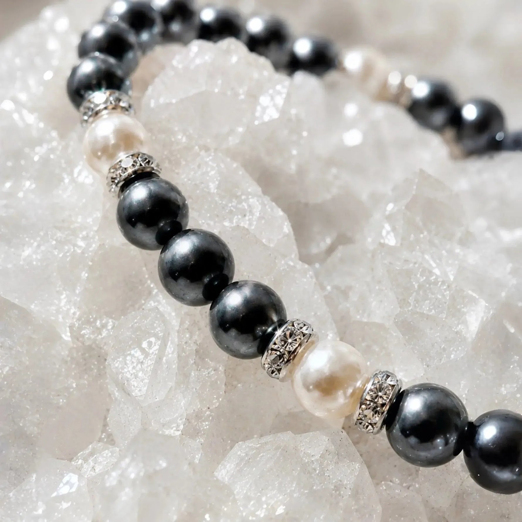 Close-up macro detail of the Jan Swarovski® Crystal Pearl Bracelet showcasing black and cream Swarovski® Crystal Pearls, sparkling crystal rondelles, and luxury handcrafted craftsmanship on white quartz crystals.