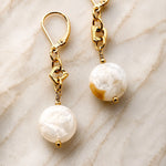 Luxury macro photograph of Jewel Cracked Agate Coin Earrings showcasing genuine cracked agate gemstones, gold-plated links, and 14k gold-filled lever back ear wires on a soft marble background.