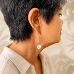 Woman wearing Jewel Cracked Agate Coin Earrings featuring genuine cracked agate gemstones and gold accents, shown in side profile with a neutral linen blouse in a refined luxury portrait.