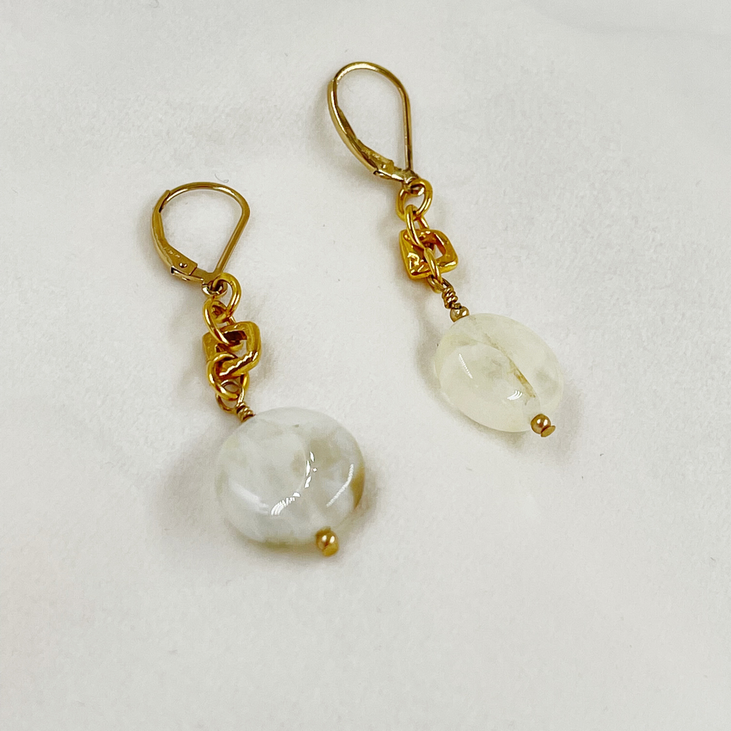 Jewel Cracked Agate Earrings displayed on a white jewelry pillow, featuring cracked agate beads, gold-plated links, and 14k gold-filled lever-back ear wires.
