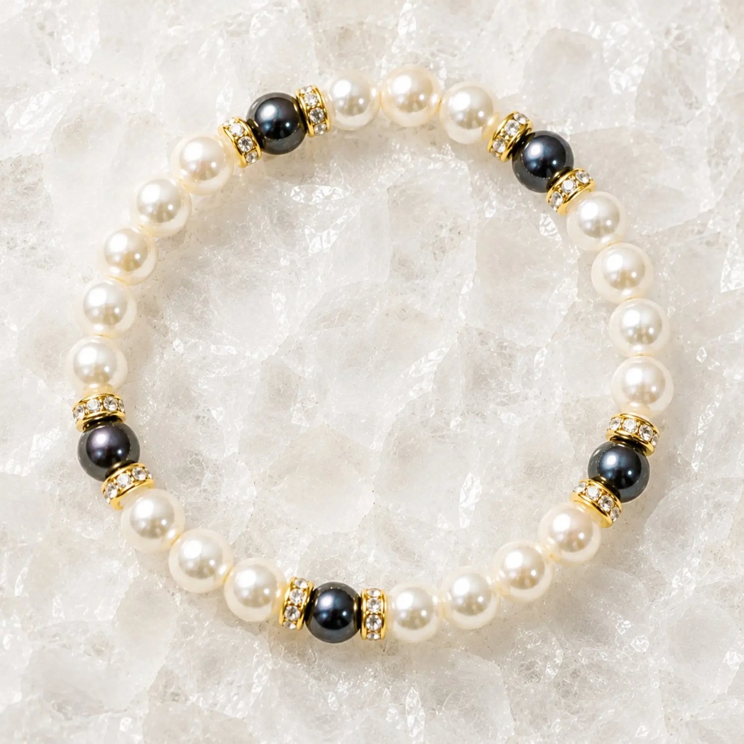 Juanita Swarovski® Crystal Pearl bracelet with cream and dark grey Swarovski® Crystal Pearls, gold crystal rondelles, displayed on luminous white quartz.