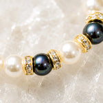 Macro detail of the Juanita Swarovski® Crystal Pearl bracelet featuring cream and dark grey Swarovski® Crystal Pearls, gold crystal rondelles, and handcrafted detailing.