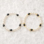 Silver and gold Juanita Swarovski® Crystal Pearl bracelets displayed together on luminous white quartz, showcasing both available finishes.