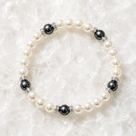 Juanita Swarovski® Crystal Pearl bracelet with cream and dark grey Swarovski® Crystal Pearls, silver crystal rondelles, displayed on luminous white quartz.