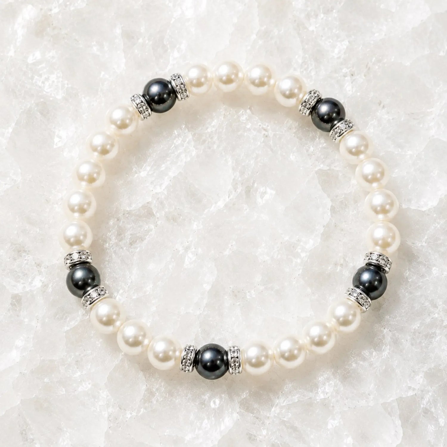 Juanita Swarovski® Crystal Pearl bracelet with cream and dark grey Swarovski® Crystal Pearls, silver crystal rondelles, displayed on luminous white quartz.