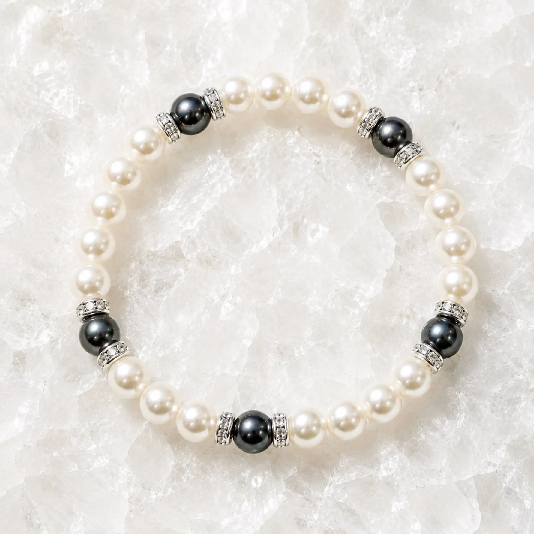 Juanita Swarovski® Crystal Pearl bracelet with cream and dark grey Swarovski® Crystal Pearls, silver crystal rondelles, displayed on luminous white quartz.