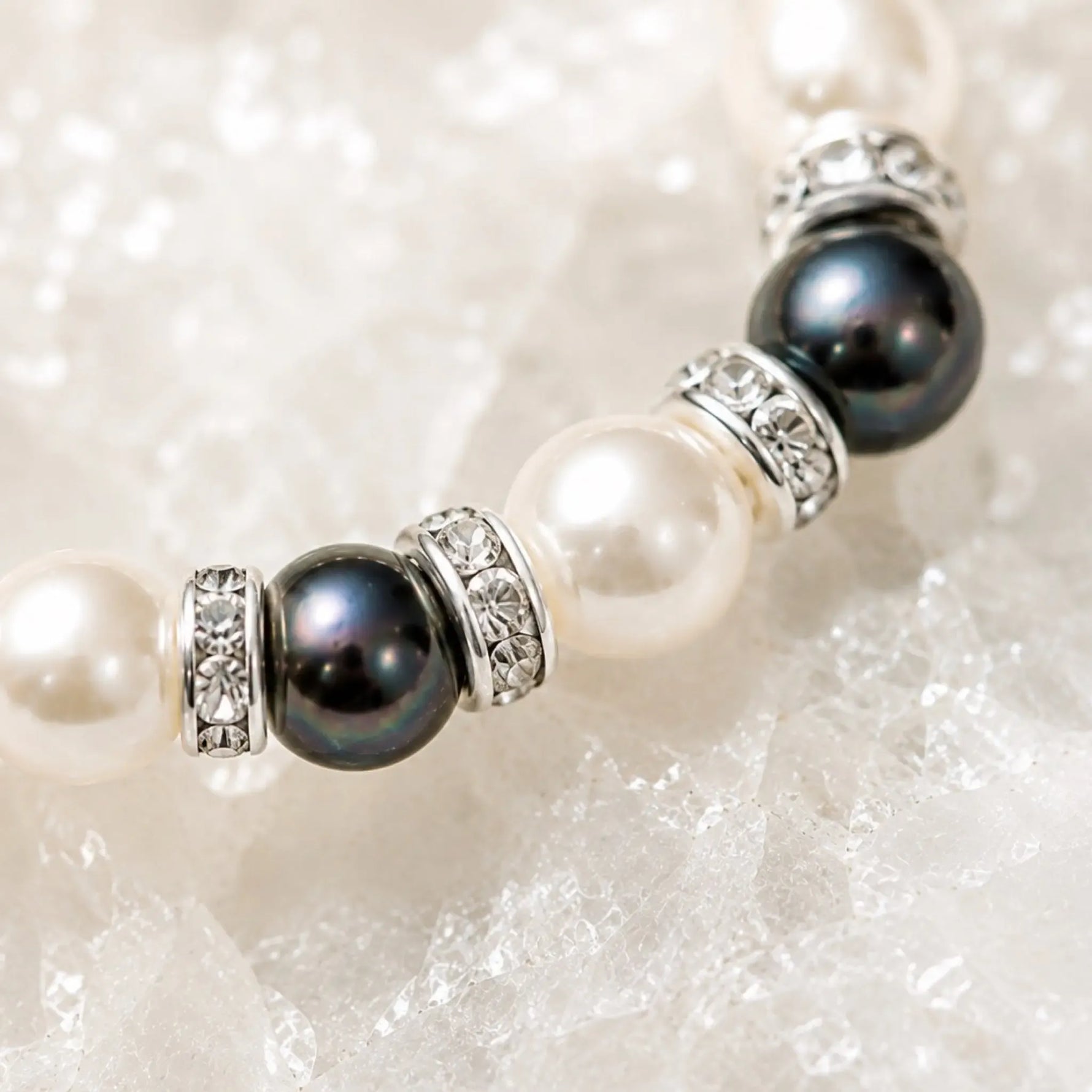 Macro detail of the Juanita Swarovski® Crystal Pearl bracelet featuring cream and dark grey Swarovski® Crystal Pearls, silver crystal rondelles, and handcrafted detailing.