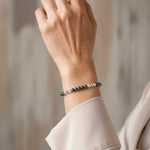 Kaia Swarovski® Crystal Pearl Bracelet worn by an elegant woman in her 50s, showcasing 4 mm Tahitian and Moonlight Swarovski® Crystal Pearls with 14k gold-filled accents in a refined editorial portrait.