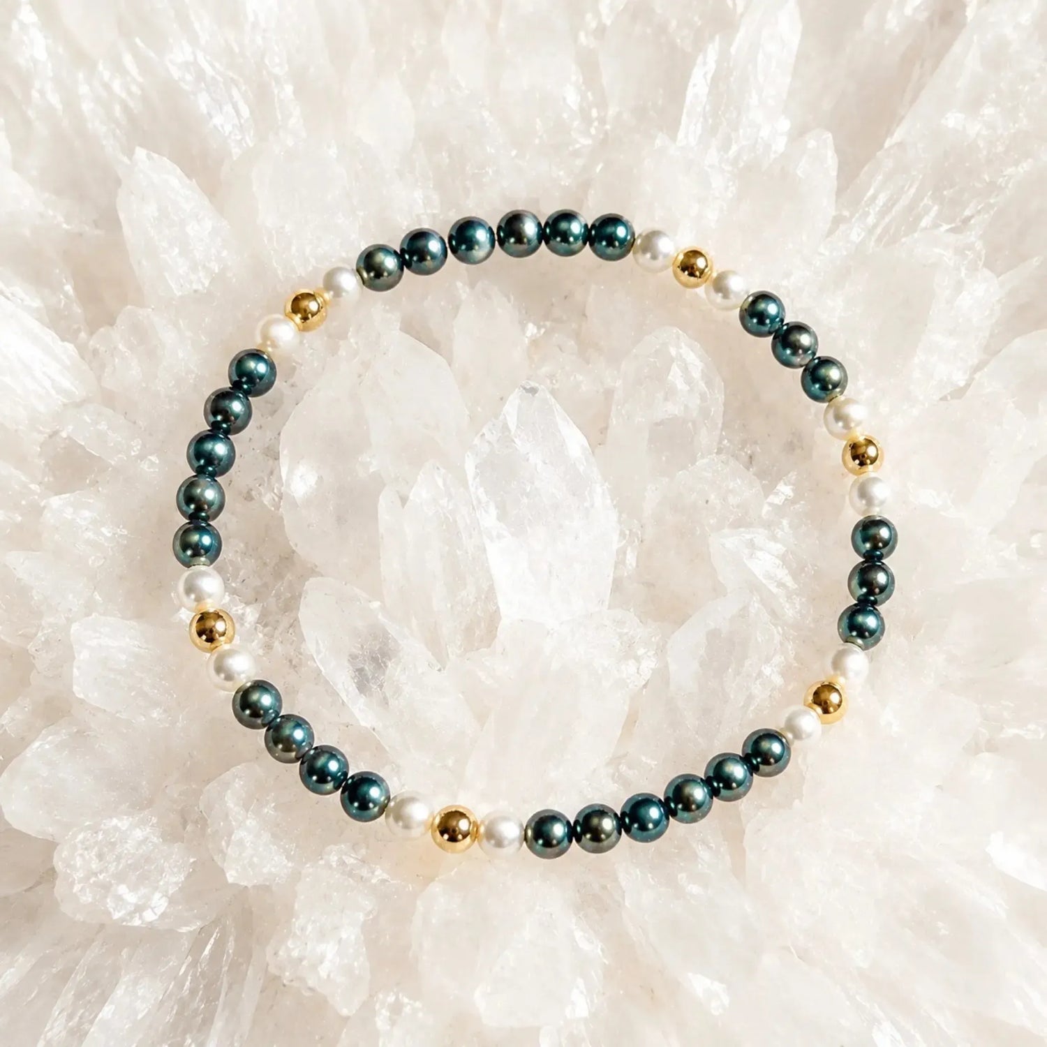 Kaia Swarovski® Crystal Pearl Bracelet featuring 4 mm Tahitian and Moonlight Swarovski® Crystal Pearls with 14k gold-filled accents arranged on a luminous white quartz crystal cluster.