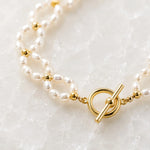 Macro detail of the Kailani Freshwater Pearl Necklace highlighting the handcrafted freshwater rice pearls, champagne gold spacer beads, and champagne gold toggle clasp.