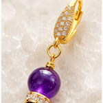 Macro detail of Kalei handcrafted amethyst gemstone earrings highlighting the 18k gold-plated CZ leverback, hand wire wrapping, Austrian crystal rondelle, and premium craftsmanship.