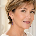 Elegant woman wearing Kalei handcrafted amethyst gemstone earrings with 18k gold-plated CZ leverbacks and Austrian crystal accents.