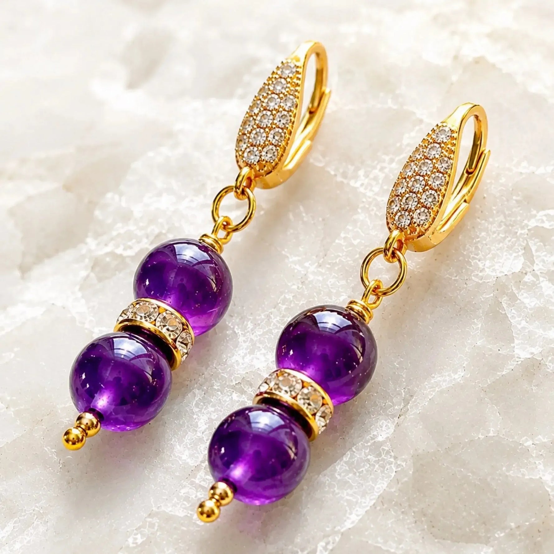 Three-quarter view of Kalei handcrafted amethyst gemstone earrings highlighting the dimensional 18k gold-plated CZ leverback design and Austrian crystal rondelles.