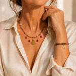 Elegant woman wearing the Layla Tourmaline Necklace and coordinating Layla Tourmaline Bracelet featuring rainbow tourmaline gemstones, ruby drops, carved jade leaf focal and gold accents.