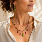 Elegant woman wearing the Layla Tourmaline Necklace and Layla Jade Earrings, featuring hand-knotted rainbow tourmaline gemstones, ruby drops, carved jade details, and gold accents in a refined editorial portrait.