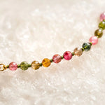 Close-up of the Layla Tourmaline Necklace showcasing faceted rainbow tourmaline gemstones in natural pink, green, honey, and watermelon tones with visible silk knotting and handcrafted detail.