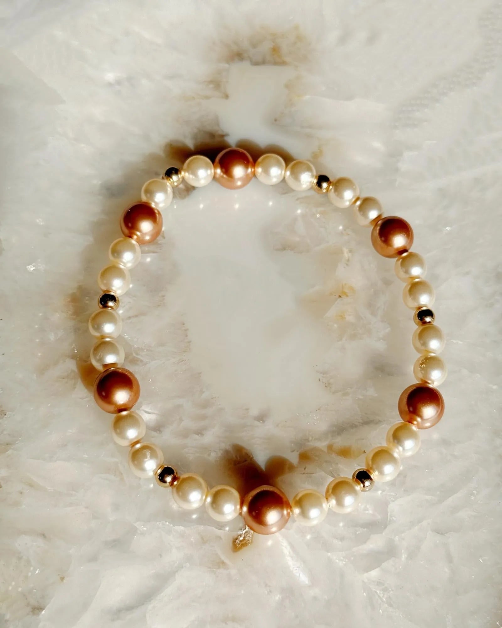 Dainty cream Austrian crystal pearl bracelet with rose gold accents in refined still life