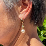 Pearl drop earrings worn by woman, gold huggie pearl earrings for mature women, classic pearl earrings for everyday wear