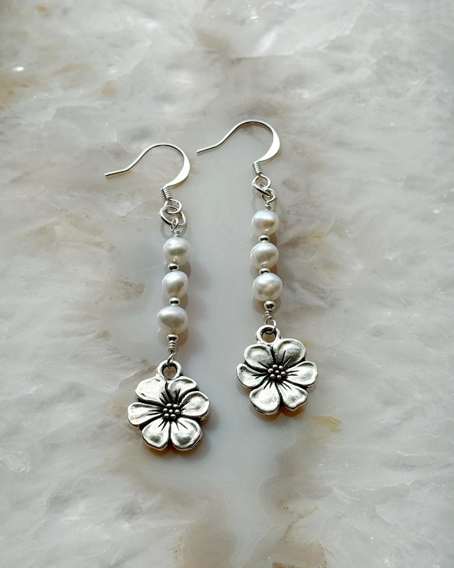 Carabella by Cheryl close-up of Mia Pearl & Apple Blossom Earrings featuring freshwater pearls, sterling silver components, and a detailed apple blossom charm — elegant handcrafted earrings.