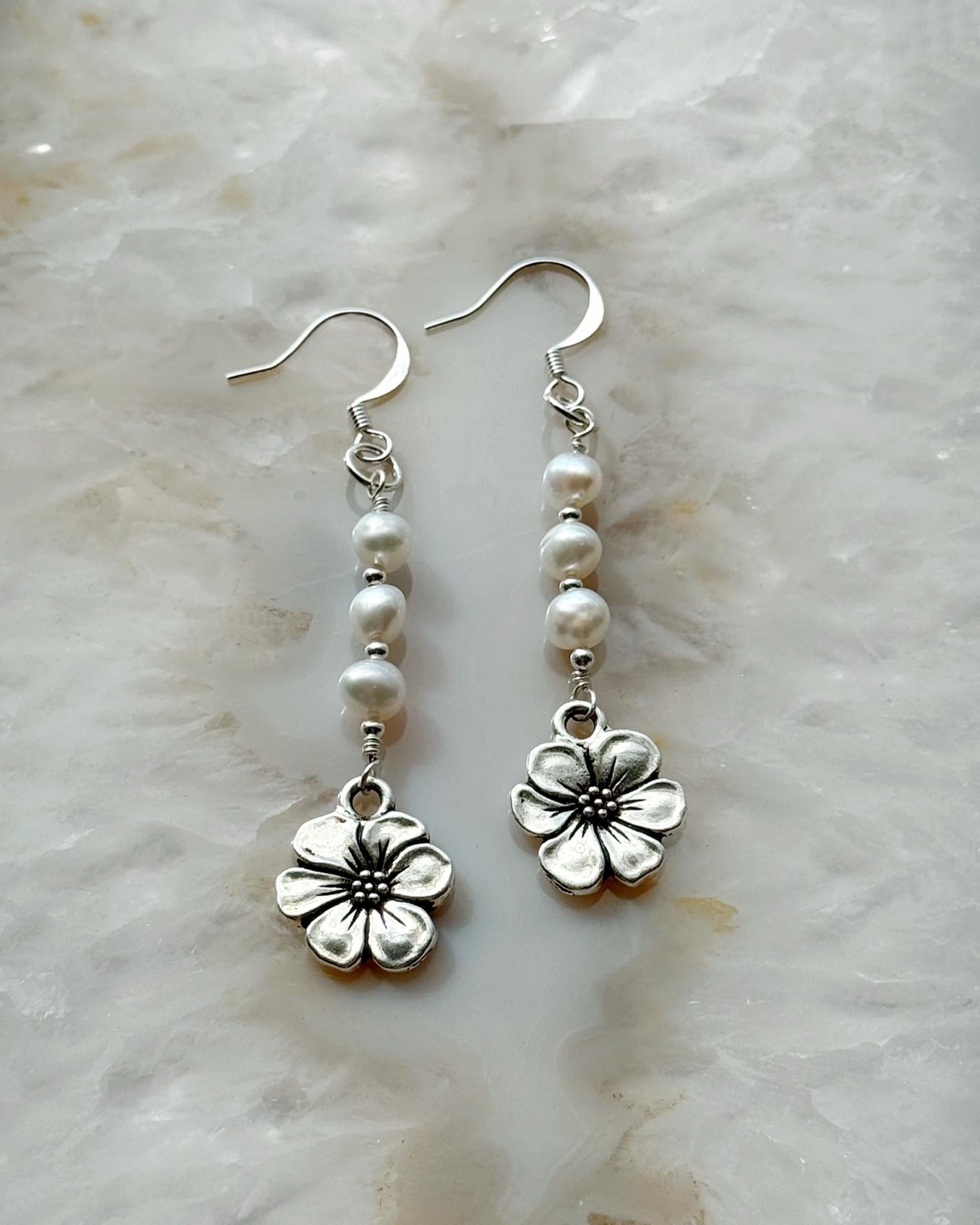Carabella by Cheryl close-up of Mia Pearl & Apple Blossom Earrings featuring freshwater pearls, sterling silver components, and a detailed apple blossom charm — elegant handcrafted earrings.