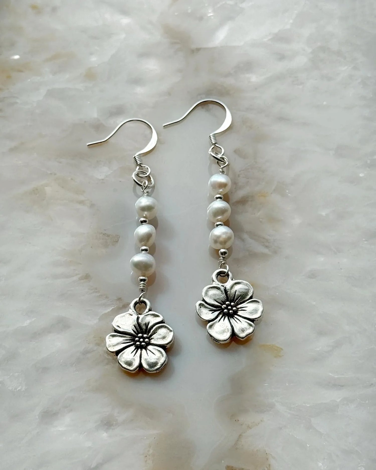Carabella by Cheryl close-up of Mia Pearl & Apple Blossom Earrings featuring freshwater pearls, sterling silver components, and a detailed apple blossom charm — elegant handcrafted earrings.
