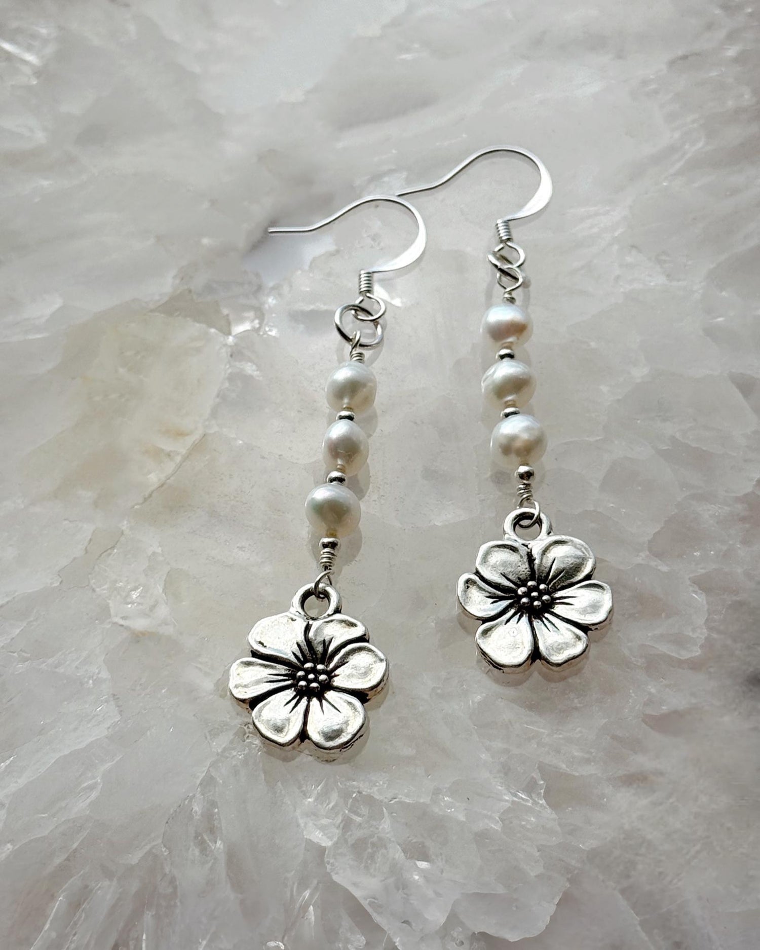 Carabella by Cheryl Mia Pearl & Apple Blossom Earrings with sterling silver and freshwater pearls displayed on a crystal background — handcrafted floral artisan jewelry.