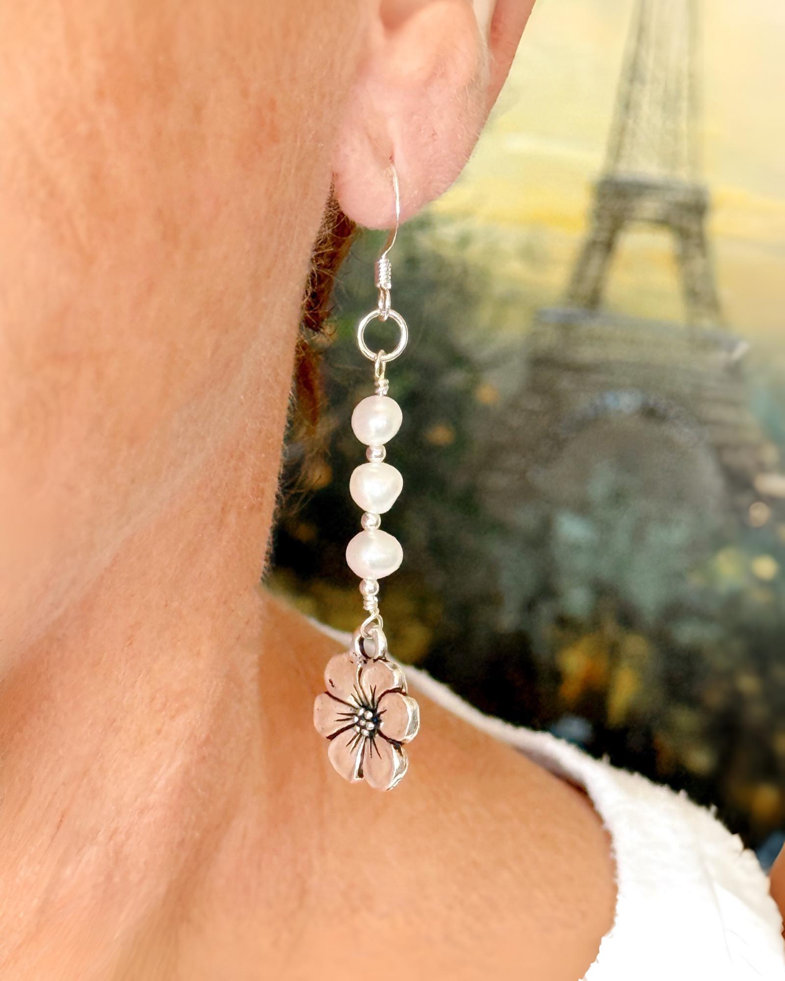 Carabella by Cheryl Mia Pearl & Apple Blossom Earrings worn by model — delicate freshwater pearl bridal earrings with sterling silver floral charm, artisan wedding accessory.