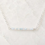 Morgan Bar Necklace featuring faceted morganite gemstones and sterling silver on a white quartz background.