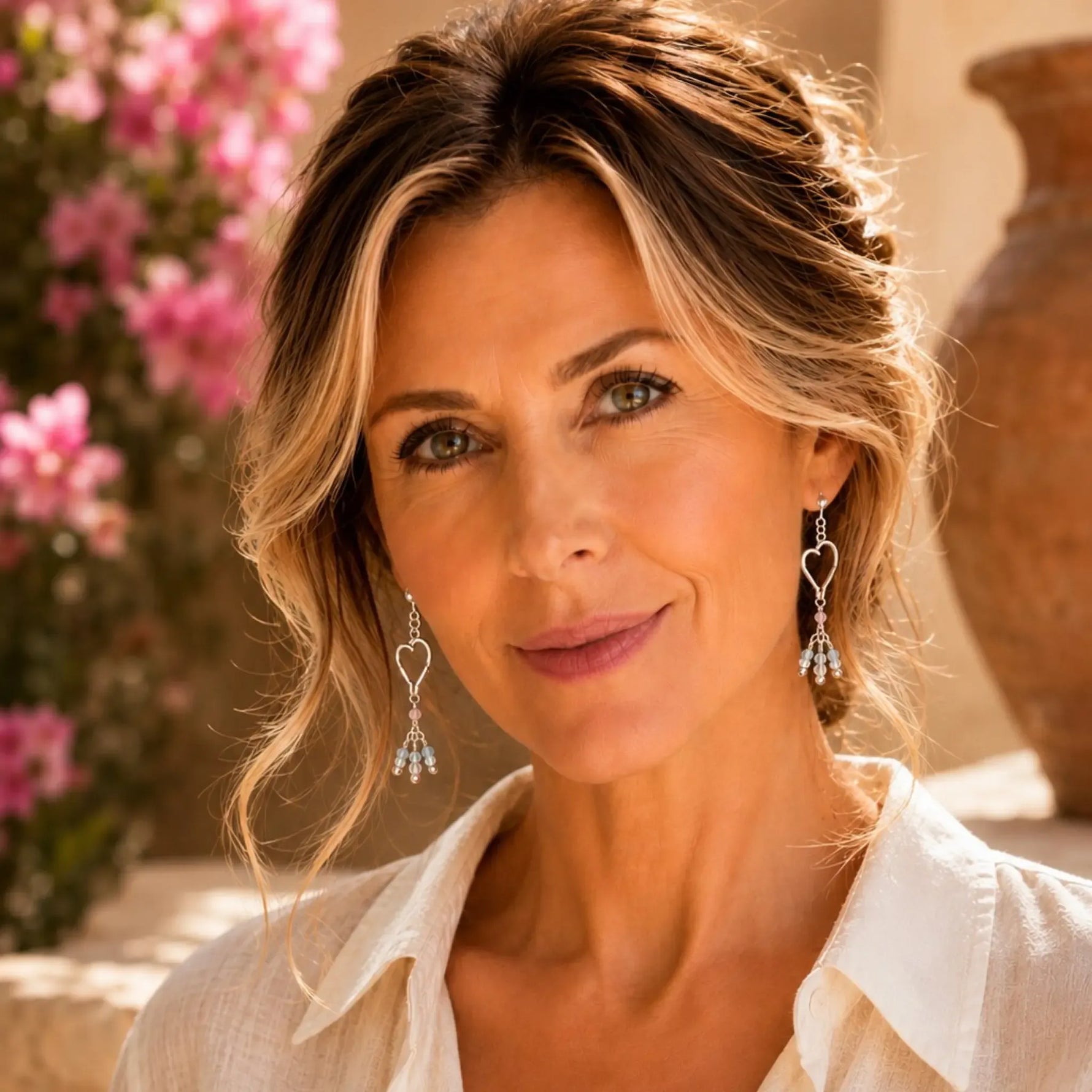 Woman wearing handcrafted sterling silver Morganite Heart Earrings with blush morganite in an elegant editorial portrait.