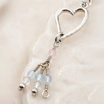 Close-up detail of the handcrafted Morganite Heart Earrings showing sterling silver wire wrapping, blush morganite, and faceted gemstone tassels.