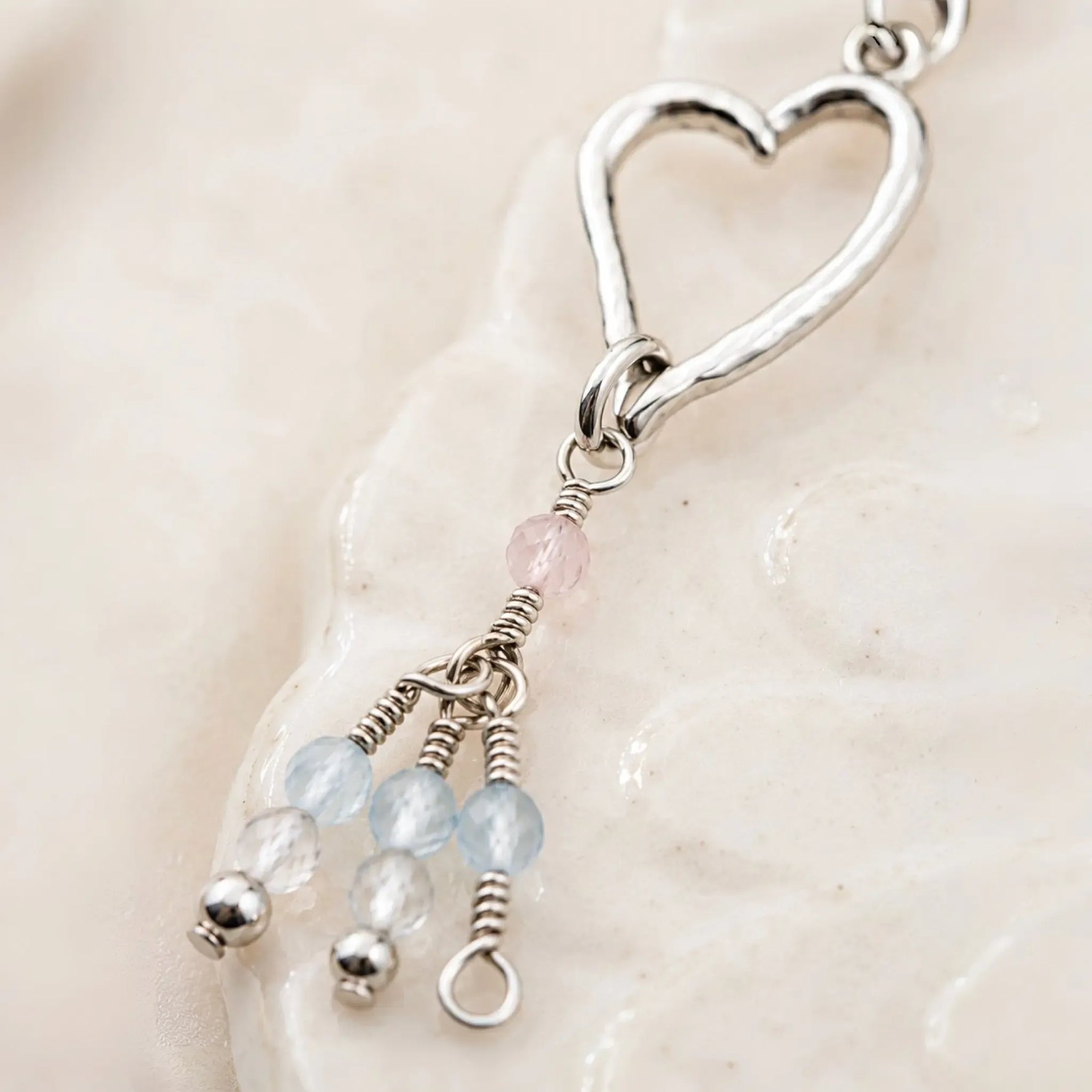 Close-up detail of the handcrafted Morganite Heart Earrings showing sterling silver wire wrapping, blush morganite, and faceted gemstone tassels.