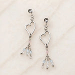 Angled view of handcrafted sterling silver Morganite Heart Earrings with blush morganite and soft blue gemstone tassels.