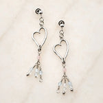 Morganite Heart Earrings handcrafted in sterling silver with blush morganite and soft blue gemstone accents on a white quartz background.