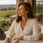 Woman wearing Natasha Swarovski® Crystal Pearl Earrings while enjoying a quiet morning overlooking a vineyard terrace, capturing refined travel and timeless elegance.
