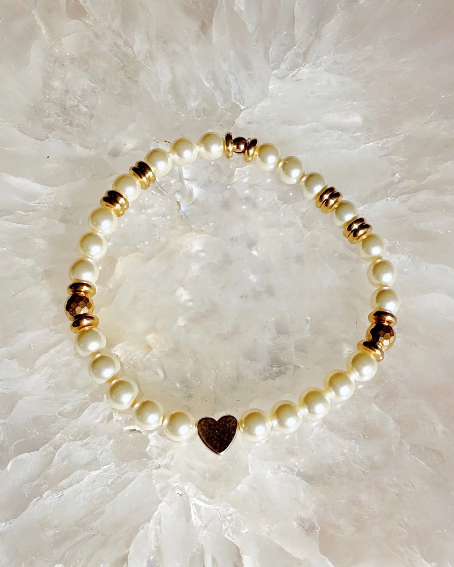 Pandora pearl and gold heart bracelet photographed on a crystal surface highlighting soft radiance and refined pearl design