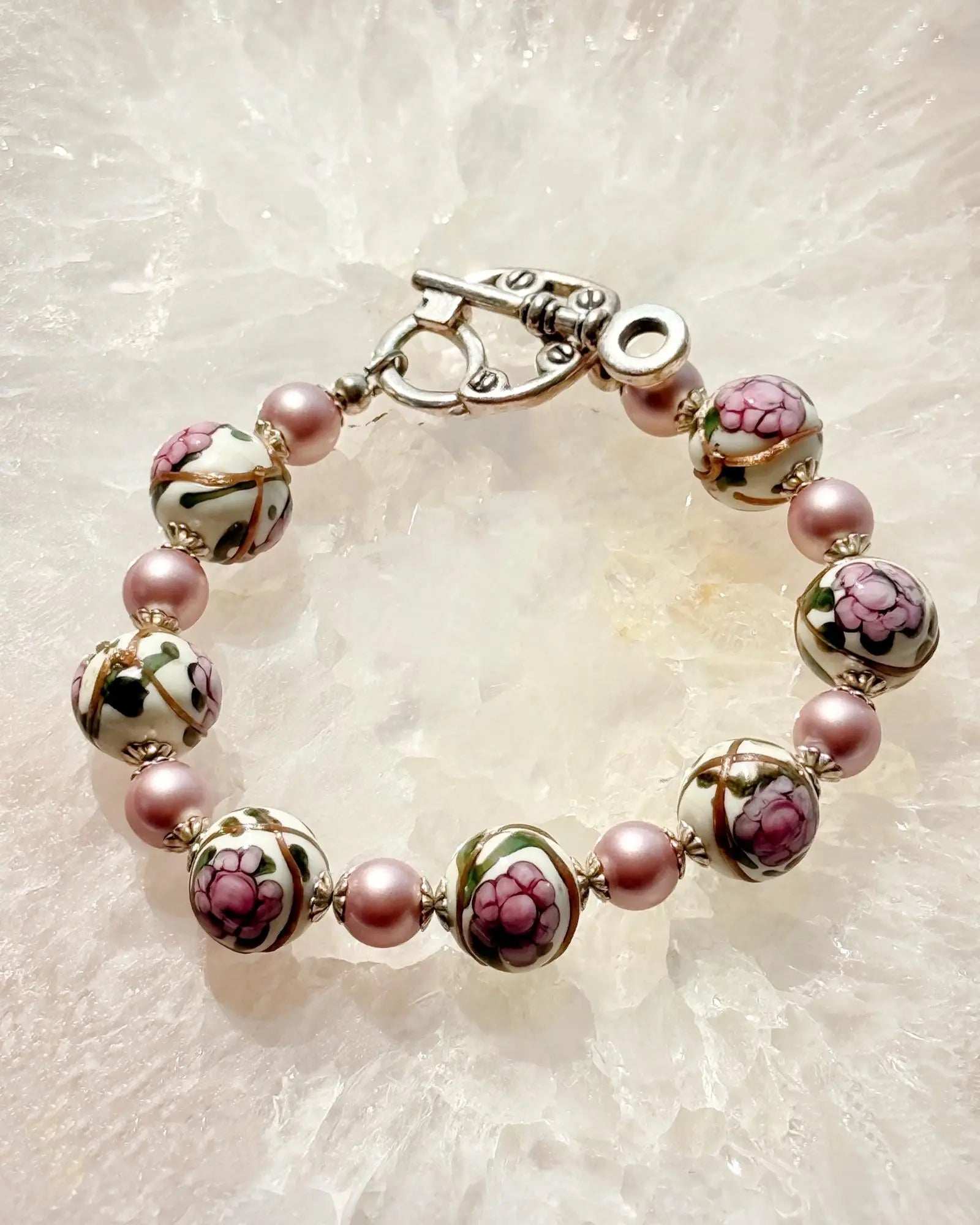 Peony Murano Glass Bracelet featuring hand-blown floral Murano beads and soft blush crystal pearls, styled on a luminous stone backdrop