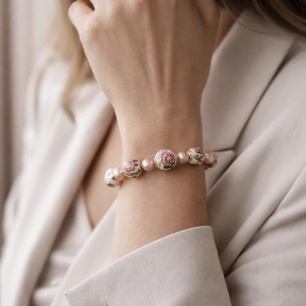 Peony Murano glass bracelet worn on the wrist, featuring hand-painted floral Murano beads and soft blush crystal pearls in an elegant, refined Carabella lifestyle setting.